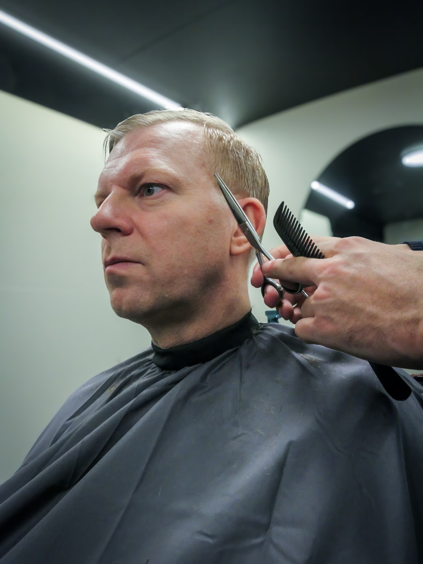 Bilde av en mann som får håret klippet i WheelCut-bilen